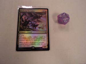 One of the promotional foil date stamped cards from the Dragons of Tarkir prerelease, and one of the five dragon brood associated spindown life counter dice.