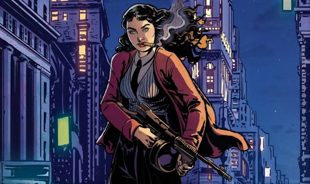 A dark-haired woman dressed in Mafioso attire holds a machine gun, smoking, with the city in the background