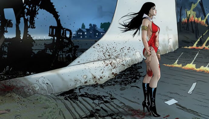 Spattered with blood, Vampirella, in costume, gazes off to the right, standing in front of a crashed jetliner