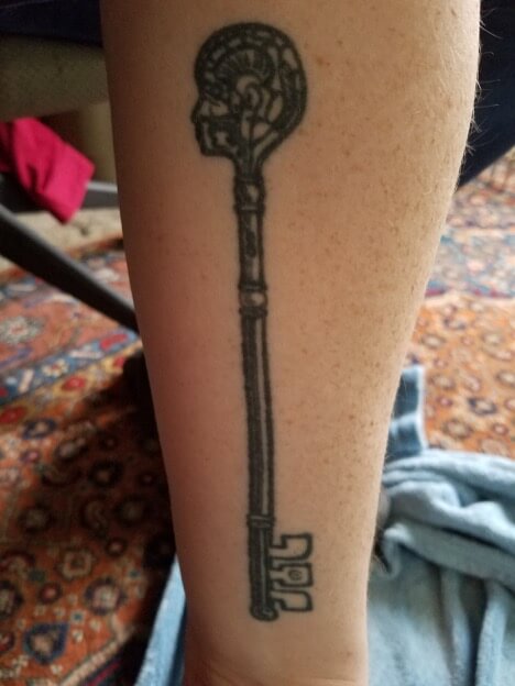 Nola's arm has an elaborate key tattoo, where the end is shaped like a head