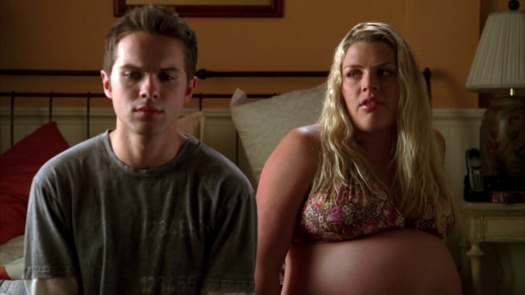 John Connor sits on a bed with a very pregnant Kacy Corbin, his neighbour and landlady