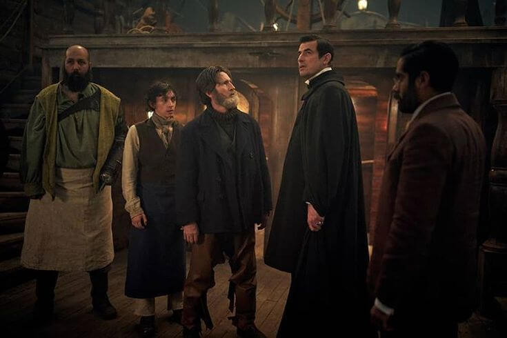 Still from episode 2 of the 2020 BBC/Netflix series Dracula, showing various members of the cast standing on the deck of a ship.