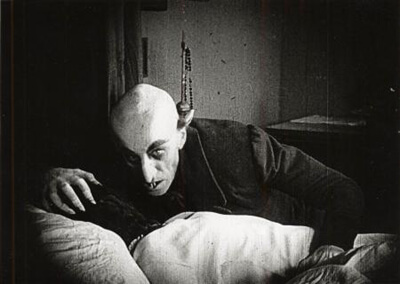 Still from the 1922 film Nosferatu showing the vampire and his victim.