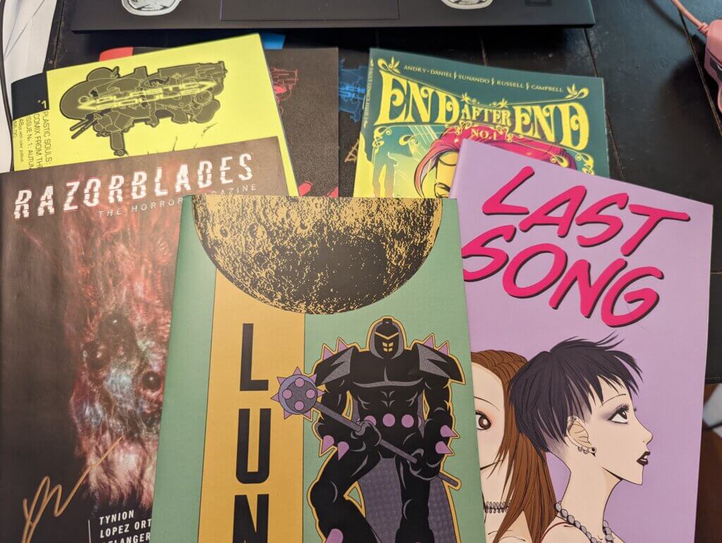 A photo depicting copies of the comics Plastic Soul 1-3, the Razorblades horror magazine, Luna #2, Last Song (a Nana tribute comic) and End After End #1, taken by Nola Pfau