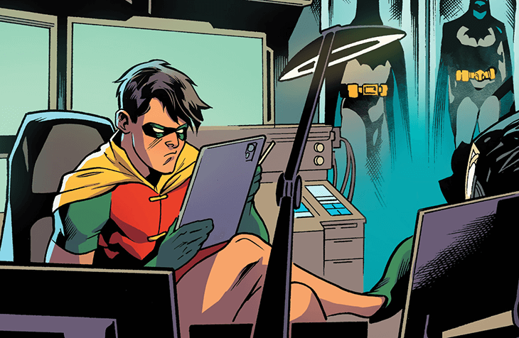Robin sitting in the Batcave looking at an IPad