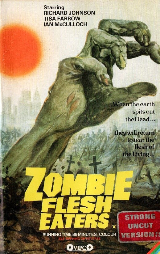 Cover of the VHs edition of Zombie Flesh Eater. Illustration shows a zombie's hand rising from the grave.