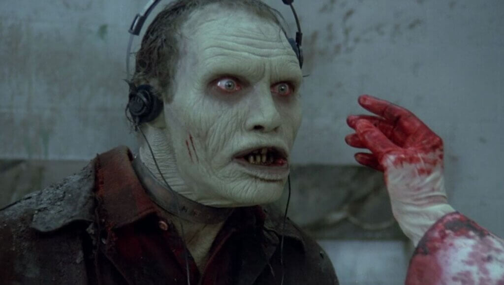 Still from Dawn of the Dead (1985) showing Bub, the test-subject zombie, wearing headphones.