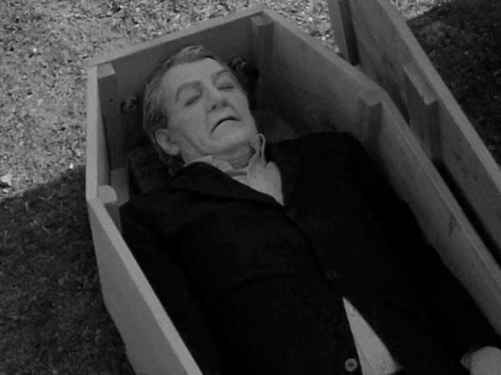 Still from one of the newly-filmed scenes for the Night of the Living Dead 30th Anniversary Edition. Bill Hinzman, playing the Graveyard Ghoul, lies seemingly dead in a coffin.