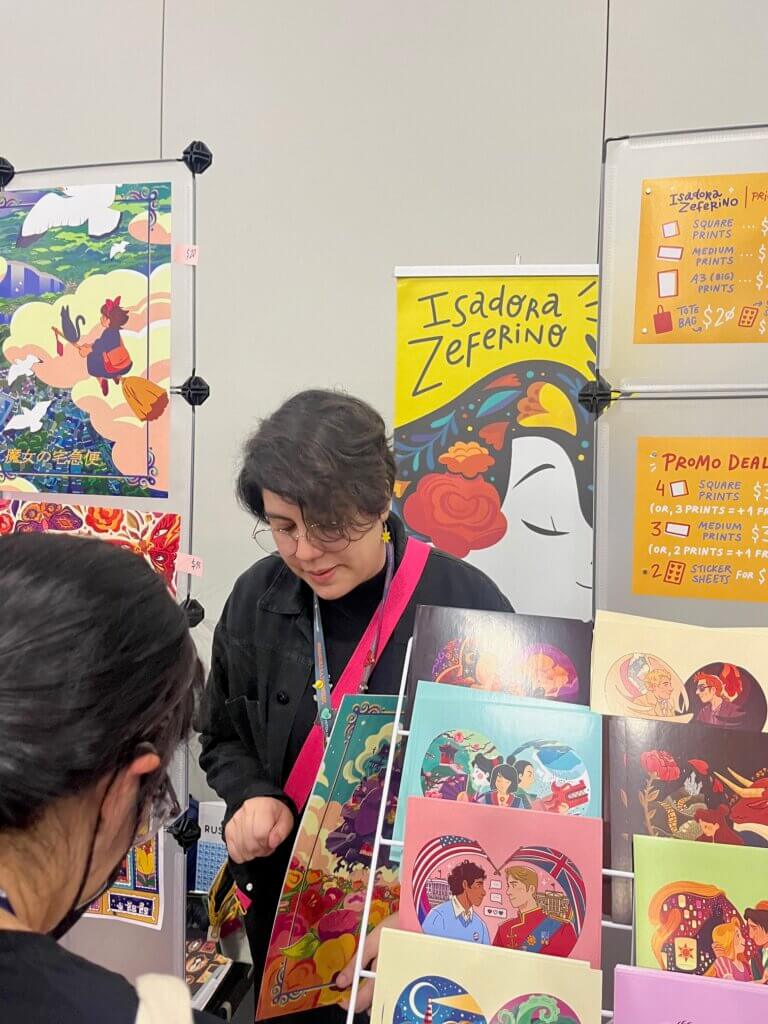 Isadora Zeferino behind her booth at NYCC 2023. 