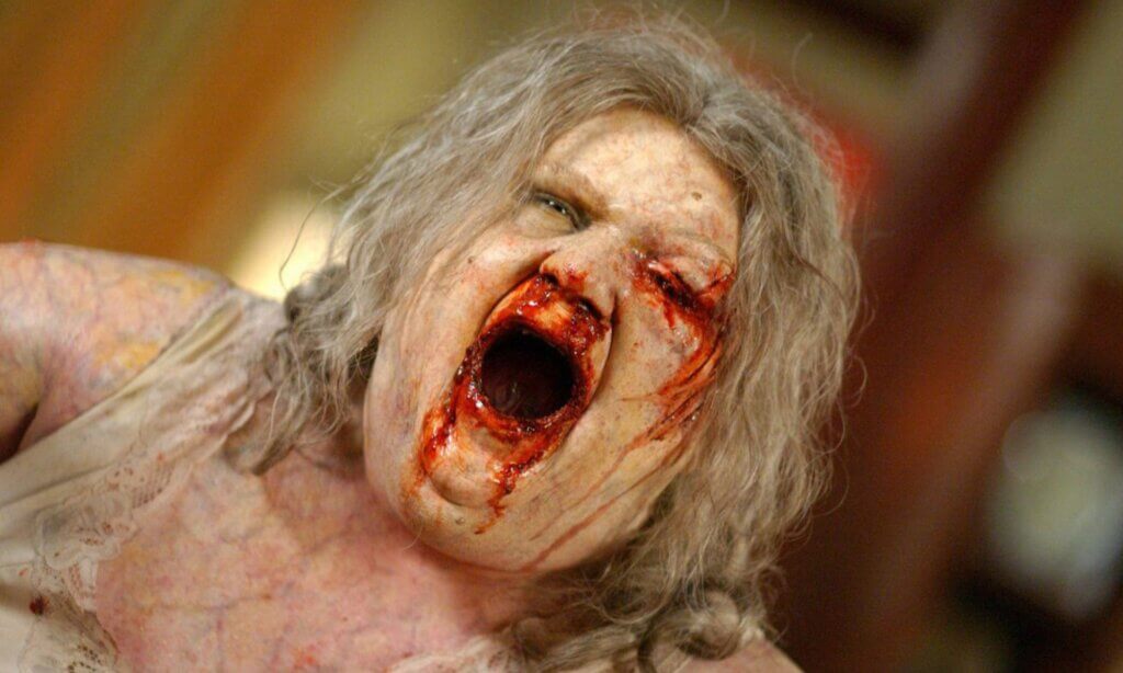 Still from the 2004 film Dawn of the Dead showing a zombie with a bloody face.