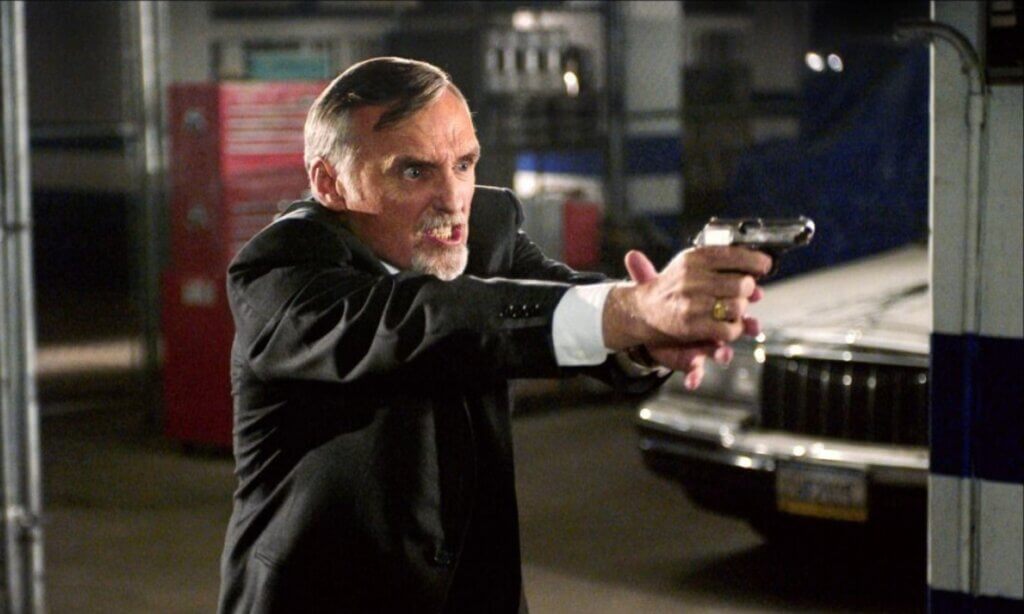 Still from the film Land of the Dead. Dennis Hopper wields a gun.