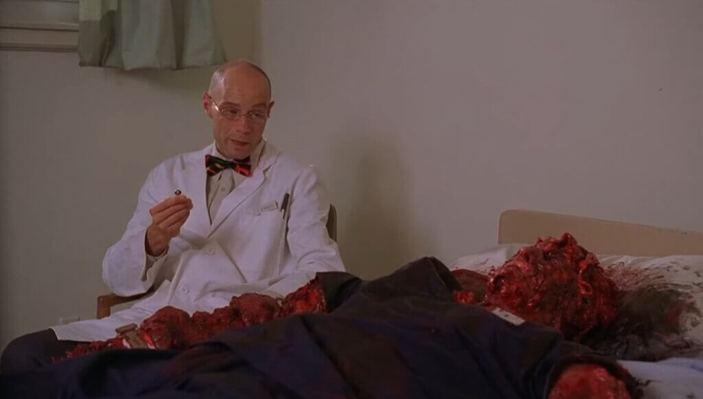 Scene from Day of the Dead 2: Contagium. A scientist observes a grotesque corpse.