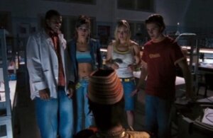 Still from the film Return of the Living Dead: Rave to the Grave. Show's the film's protagonists gathered together in a laboratory.