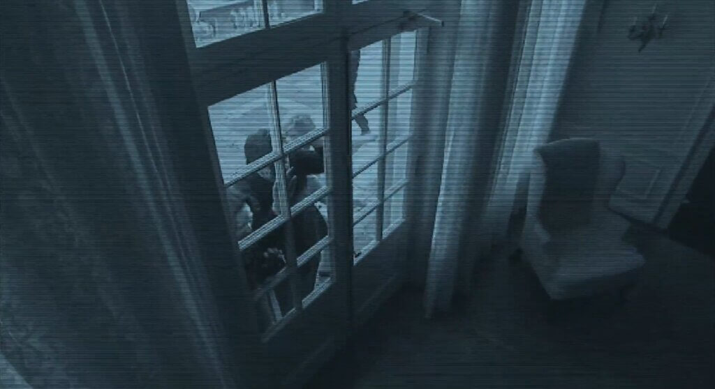 Still from the film Diary of the Dead showing CCTV footage of zombies at a glass-panelled door.