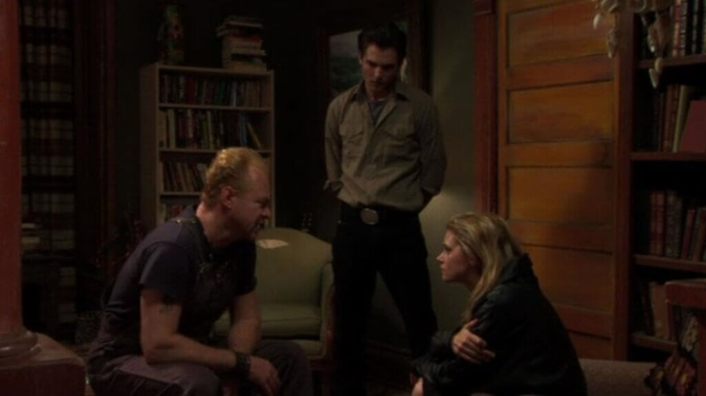 Still from the film Night of the Living Dead 3D. Three people gathered in a house.