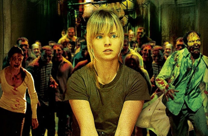 Detail from a publicity image for the 2008 film Day of the Dead, showing a young woman surrounded by zombies.