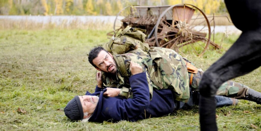 Still from the film Survival of the Dead. Two men grapple with each other in a farm.