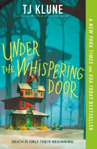 The cover of Under the Whispering Door by TJ Klune shows a precariously balanced house in bright colors with a shadow of a beast behind it